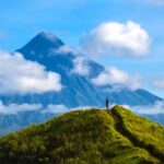 Hiker with backpack looks at the view on the Mayon volcano,Philippines_shutterstock_612038996