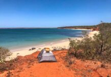 La West Coast australiana da Broome a Perth Una tenda in spiaggia dove la costa occidentale dell'Australia dove la terra rossa incontra l'Oceano